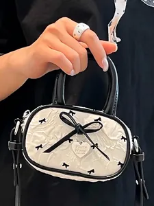 Mini sac à main blanc avec imprimés nœuds noirs, grand nœud et pendentif en cœur