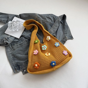 Detail view of colorful 3D crochet flowers on a yellow hand-woven knit tote bag