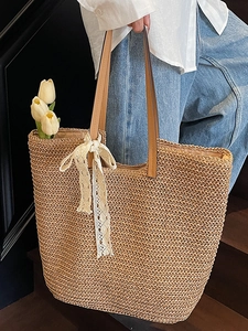 Handwoven straw tote bag with lace ribbon and leather straps for summer beach travel
