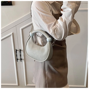 Detail view of light grey pleated half-moon bag with blue bead handle accents