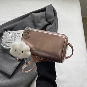 Details der roségoldenen Metallic-Zylindertasche mit flauschigem Wolkenanhänger