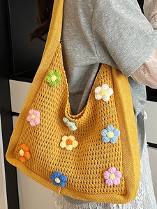 Handmade crochet shoulder bag with colorful floral patterns in a bohemian knit style
