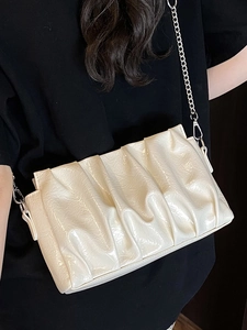 Sac nuage froncé beige chic avec bandoulière chaîne argentée et fini cuir verni