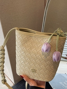 Beige woven leather bucket bag with purple tulip detail and braided shoulder strap