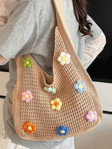 Handmade crochet tote bag with colorful 3D flowers and wide shoulder strap on model