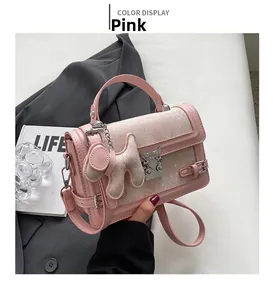 Detail of pink embroidered handbag with silver wing clasp and cute puppy charm
