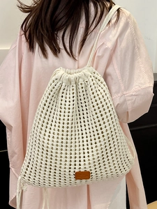 Minimalist white knit mesh drawstring backpack with brown leather patch on model back
