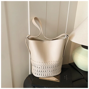 Detail of laser-cut petal patterns and adjustable strap on the off-white bucket bag