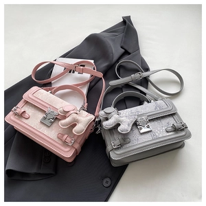 Close-up of jacquard fabric crossbody bags with silver metal locks and cute dog charms