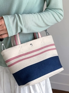 Minimalist canvas bucket bag with color-block woven stripes and detachable shoulder strap