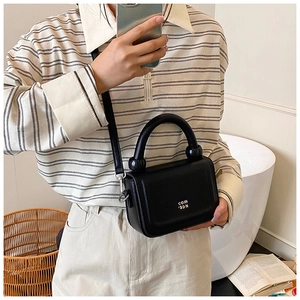Fashionable black structured handbag with white text print and thick handle detail