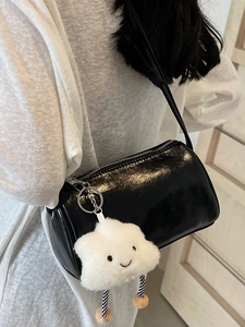 Trendige schwarze glänzende Zylindertasche mit süßem weißem Plüschwolken-Anhänger