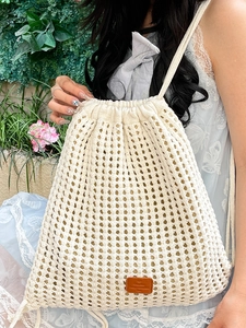 Minimalist cream knit drawstring backpack featuring bohemian crochet hollow mesh design