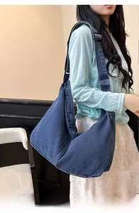 Détail de la bandoulière réglable et de la texture denim de ce grand sac hobo spacieux