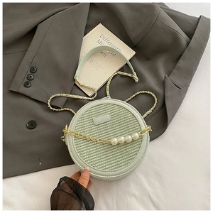 Détail du petit sac rond en paille vert menthe avec chaîne dorée et perles