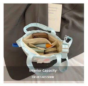 Dettaglio dell'interno capiente di questa borsa a secchiello in tela a pois blu