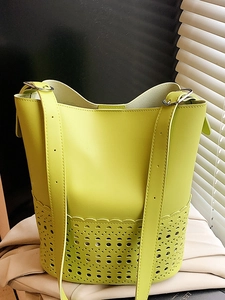 Chic lime green cutout bucket bag with carved patterns and adjustable shoulder strap