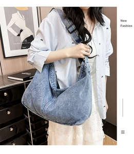 Détail de la bandoulière large réglable et du denim bleu délavé du grand sac bandoulière