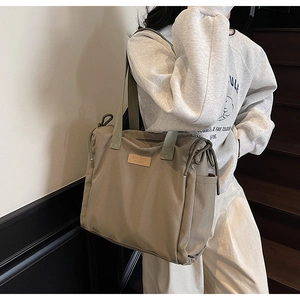 Detail of khaki large canvas tote bag with BUDBAG leather logo and drawstring accents