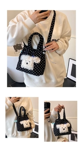 Dettaglio della borsa in tela nera a pois con ricamo di un cucciolo in peluche e fiocco