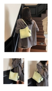 Detail of light green litchi grain leather bucket bag with a mini zipper coin purse