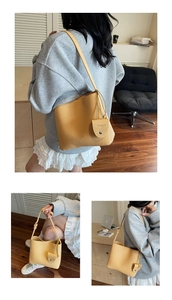 Detail of yellow leather bucket bag with drawstring closure and matching mini pouch