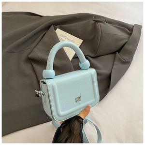 Close-up of a light blue litchi pattern mini handbag with silver logo and ball handle
