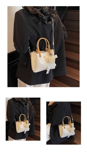 Detailed macro view of cream PU leather bucket bag with lacy ribbon and pearl heart charm