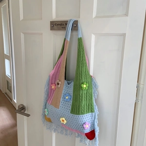 Detailed close-up of bohemian knit tote bag with colorful patchwork and floral tassels