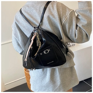 Detailansicht der schwarzen Totebag mit Krokoprägung, Kordelzug und Vordertasche mit Schnalle