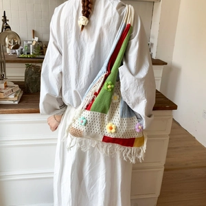 Detailed view of handmade crochet tote bag with colorful patchwork flowers and long tassels