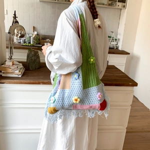 Detail of colorful crochet tote bag with 3D floral accents and fringe trim finish