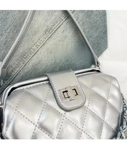 Detail of silver quilted leather handbag featuring metal twist lock and chain strap