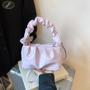 Detail of lavender pleated cloud bag showing soft leather texture and golden chain