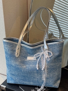 Denim tote bag with silver leather trim, sequins, and a pearl bow charm for daily commuting