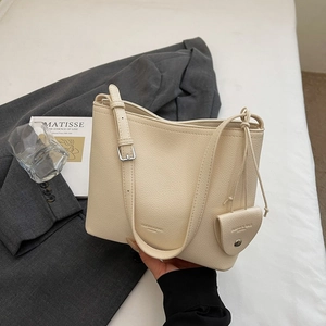 Detailed macro view of cream pebbled leather texture on minimalist bucket bag