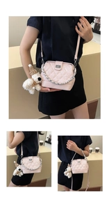 Detail view of pink quilted handbag with gold chain strap and cute plush dog pendant