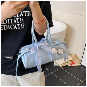 Détail d'un sac Boston en cuir verni bleu clair avec dentelle et nœud à carreaux élégant