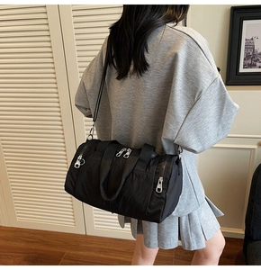 Detail of black nylon duffel bag featuring adjustable straps in a modern home setting