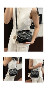 Detail of black quilted leather handbag with silver chain and cute white sheep charm