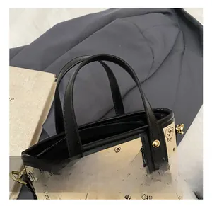 Detail showing the comfortable black carry handle and golden metal rivets on the tote bag