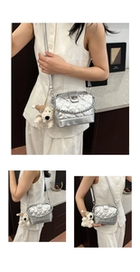 Macro detail of silver quilted crossbody bag with stylish chain and cute puppy plush charm