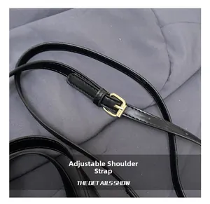 Detail of adjustable black faux leather shoulder strap with elegant gold metal buckle