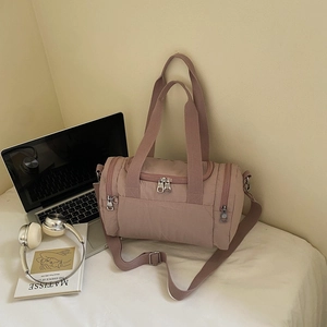 Detail of mauve nylon fitness bag showing durable handles and adjustable shoulder strap