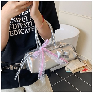 Détail du sac à main argenté métallisé avec nœud à carreaux rose et ruban en dentelle chic