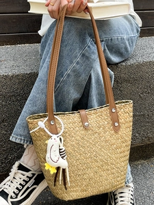 Handwoven straw tote bag with brown leather straps and cute plush chick pendant charm