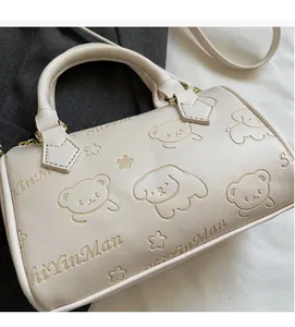 Close-up of cream white Boston bag with animal star embossing and golden hardware