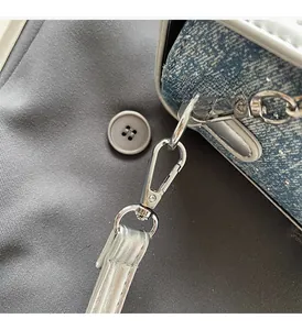 Dettaglio della borsa porta cellulare in denim glitterato con moschettone in argento lucido
