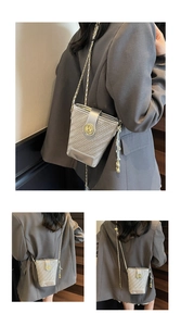 Détail du sac seau tissé argenté avec boucle métallique et bandoulière en chaîne