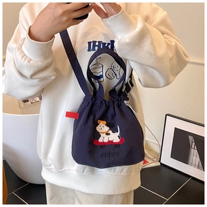 Dettaglio borsa a secchiello in tela blu navy con ricamo cucciolo e coulisse regolabile
